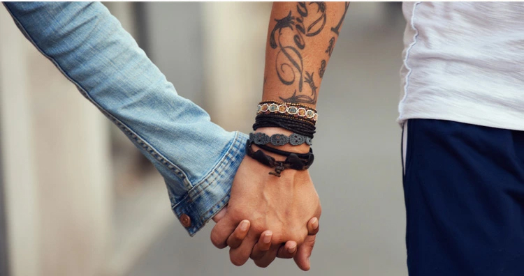 Bracelet pour le Réveillon de Noël : Élégance scintillante et confort festif Couple mains serrées avec bracelet au poignets
