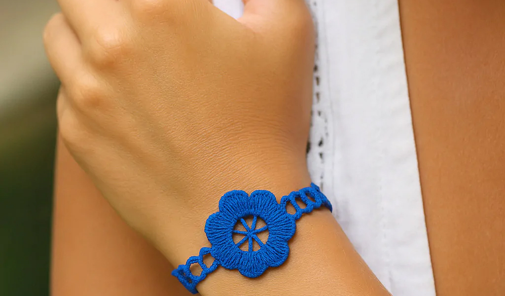 Bracelets pour Femme en 2024 : Tendances, Styles et Inspirations Poignet feminin orne d'un bracelet Peace bleu en tissu