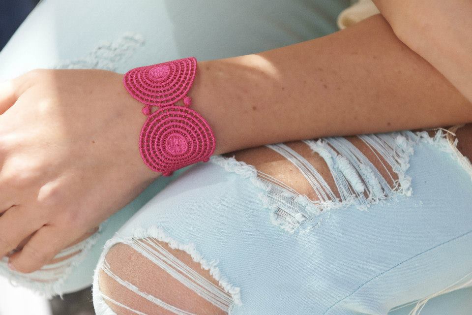 Un gros bracelet manchette de couleur rose bombon porté avec une tenue décontractée