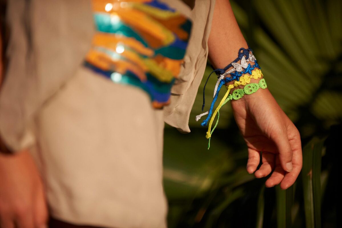 Un Bracelet manchette fleur confectionné en fil satiné pouvant se marier avec de nombreuses tenues