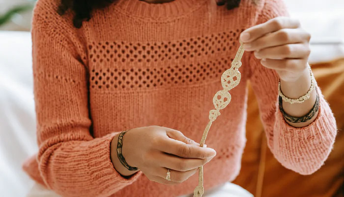 Bracelet en tissu à faire soi-même : les matériaux à utiliser Une femme est en train de personnaliser son bracelet