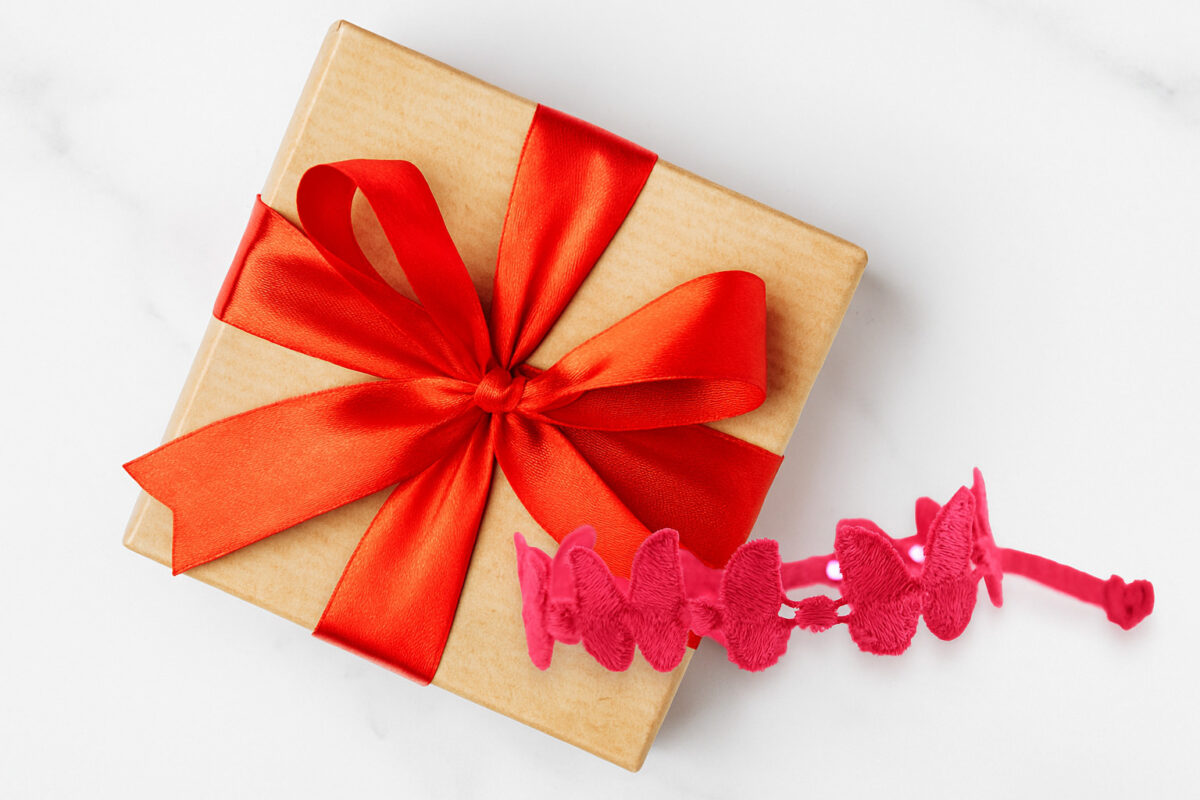 Un bracelet en tissu personnalisé comme cadeau d’anniversaire ? Bracelet manchette papillon sur un boite de cadeaux