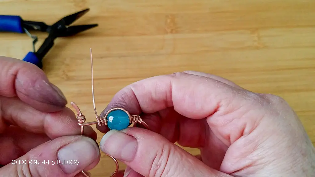 Cette image montre à quoi devrait ressembler la bobine enroulée une fois enroulée autour de l'armature métallique, sur la perle, puis enroulée à nouveau trois fois autour de l'armature métallique.