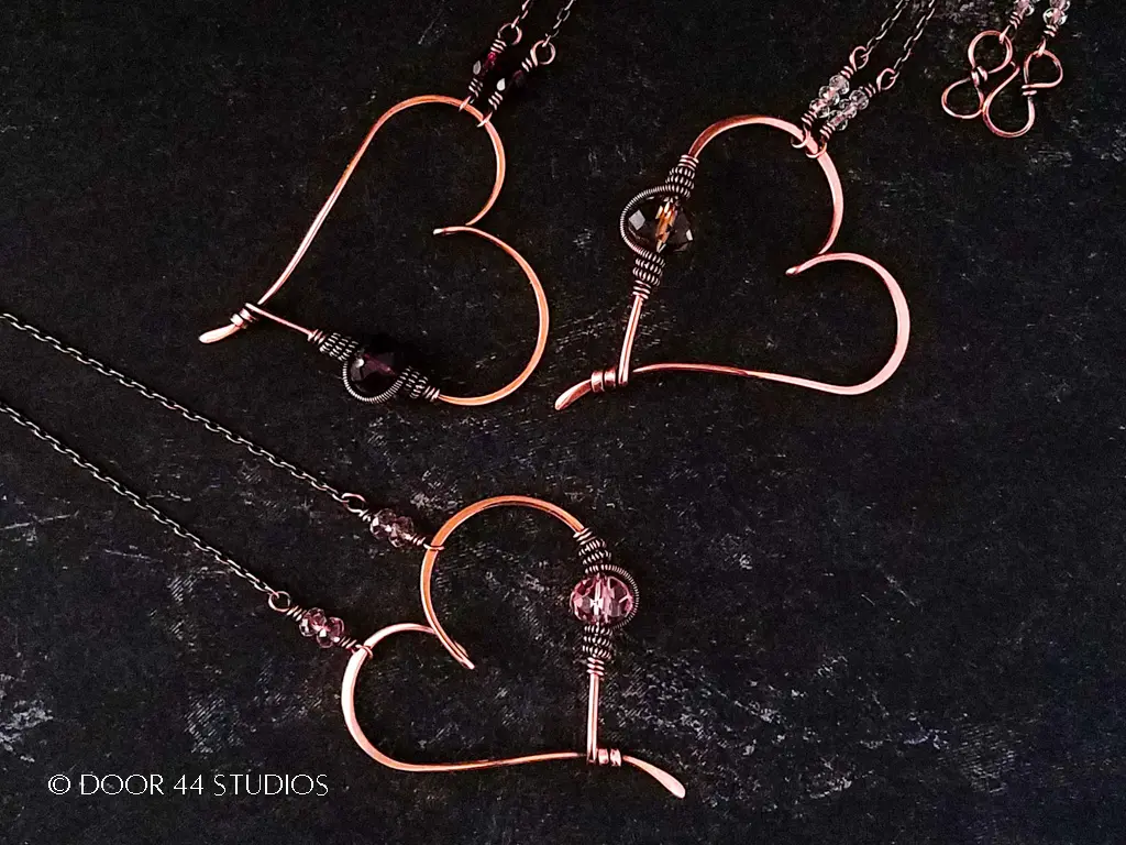 Trois pendentifs coeur en fil rapide et facile en cuivre avec des perles d'accent roses, grises et violettes