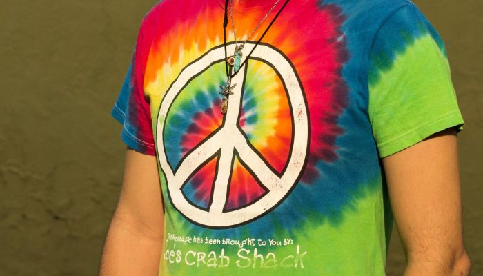 Un collier hippie porté par un homme avec une tenue de couleur vive et décontractée Un collier hippie porté par un homme avec une tenue de couleur vive et décontractée