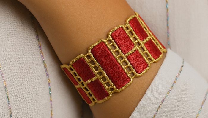 Bracelet brodé josephine rouge et or sur poignet féminin Bracelet brodé josephine rouge et or sur poignet féminin