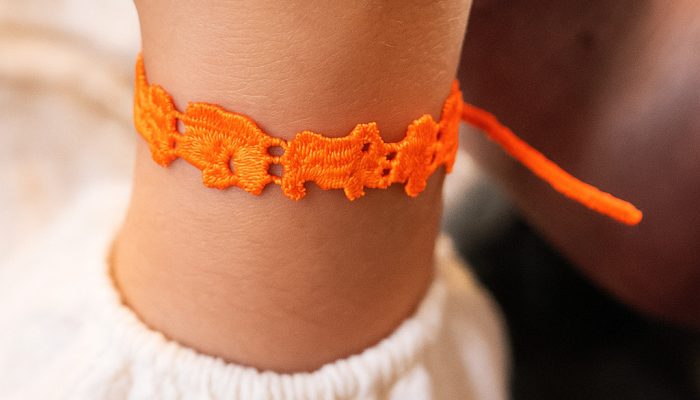 Bracelet en dentelle tressée sur poignet d’enfant Bracelet en dentelle tressée sur poignet d'enfant
