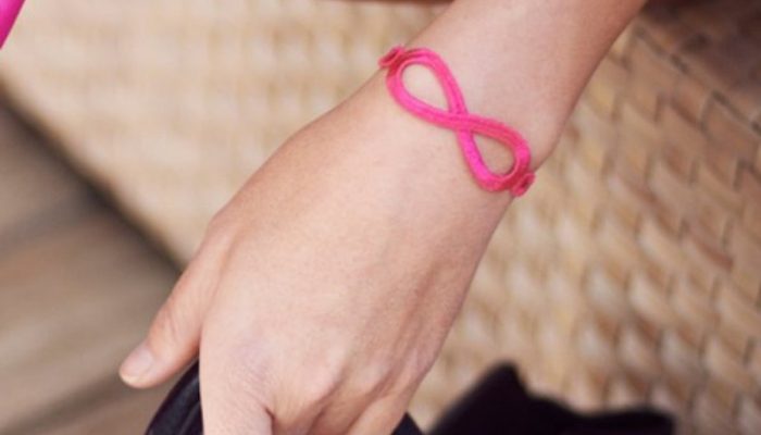 Bracelet infini rose fluo sur un poignet femme Bracelet infini rose fluo sur un poignet femme