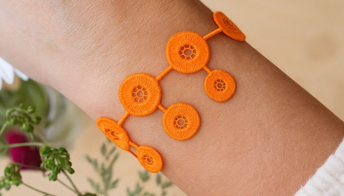 Poignet orné d’un bracelet orange ajouré Poignet orné d’un bracelet orange ajouré